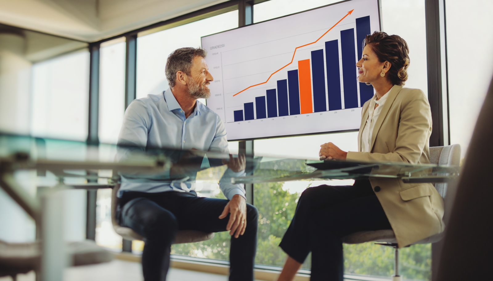 Advisor and client reviewing financial charts in a modern conference room